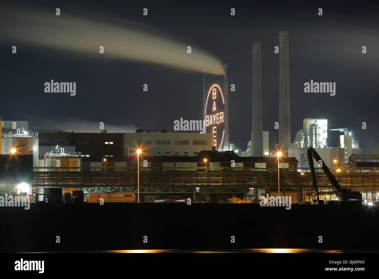 Bayer factory buildings and premises with the Rhine river in the foreground, night shot, Leverkusen, North Rhine-Westphalia, Ge Stock Photo