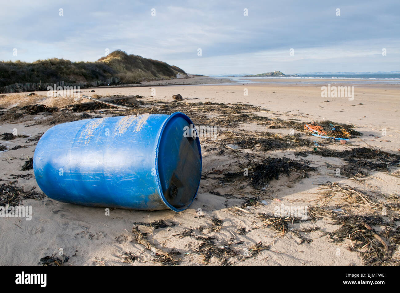 A large blue plastic oil drum washed up on a beach in the Firth of Forth, Scotland. Stock Photo