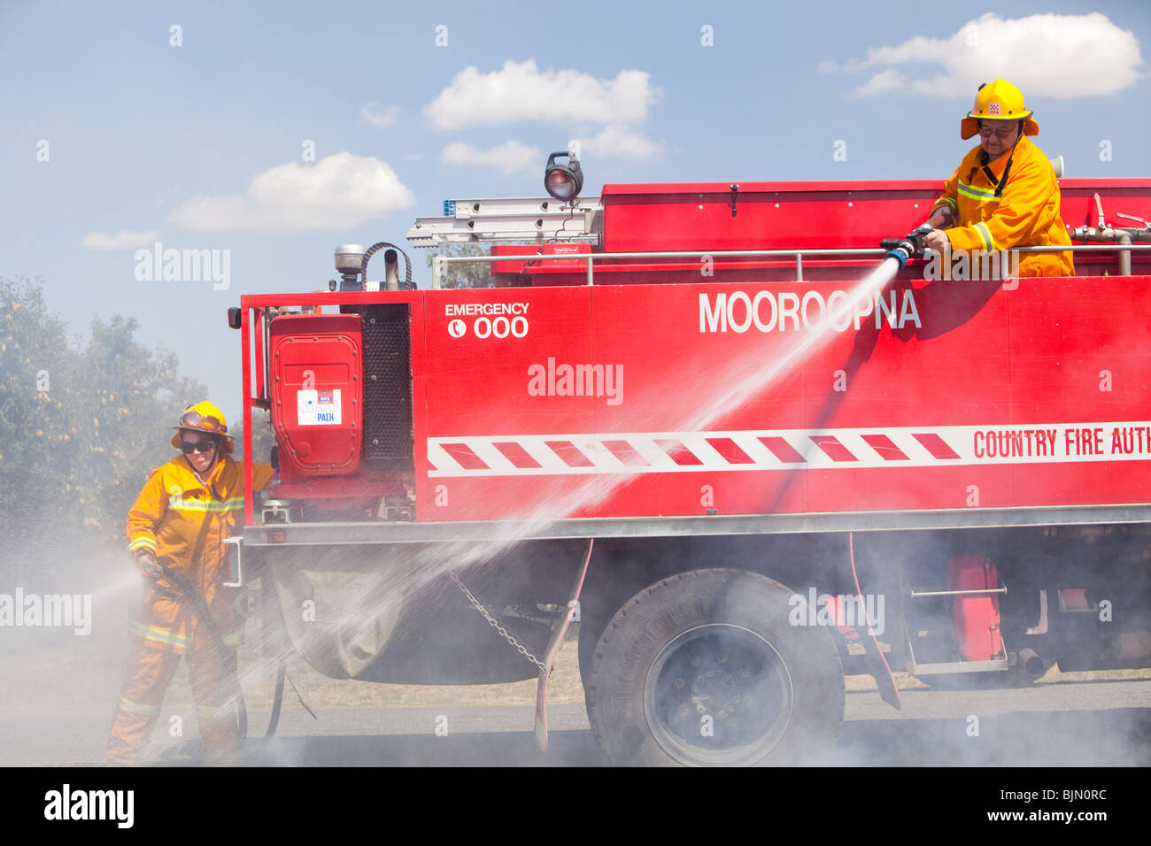 CFA fire fighters tackle a roadside fire near Shepperton, Victoria, Australia. Stock Photo