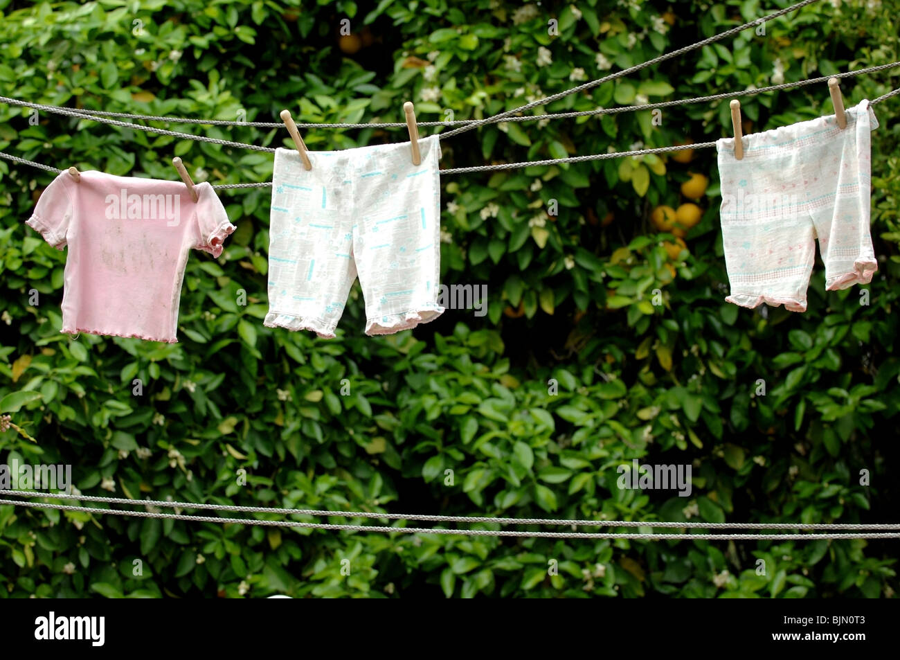 Vintage children's clothing drying on a clothes line with held with