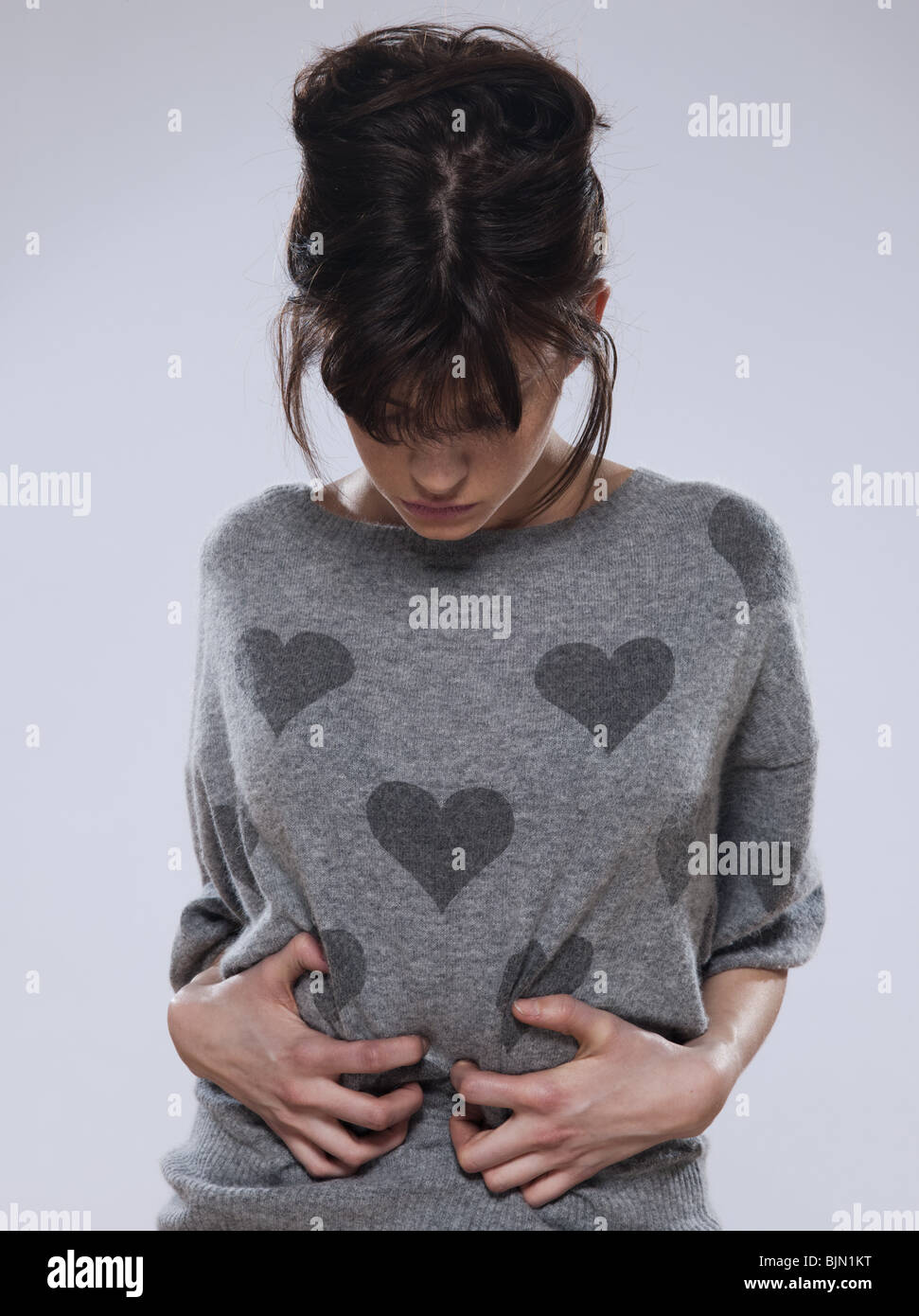 beuatiful caucasian brunette young woman wearing a sweater with hearts on it Stock Photo