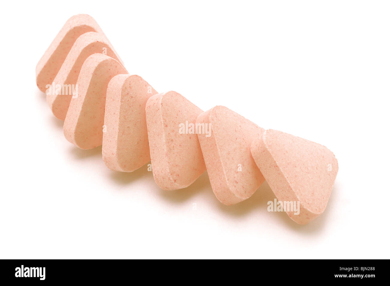 triangular shape vitamin tablets arranged on white background Stock Photo