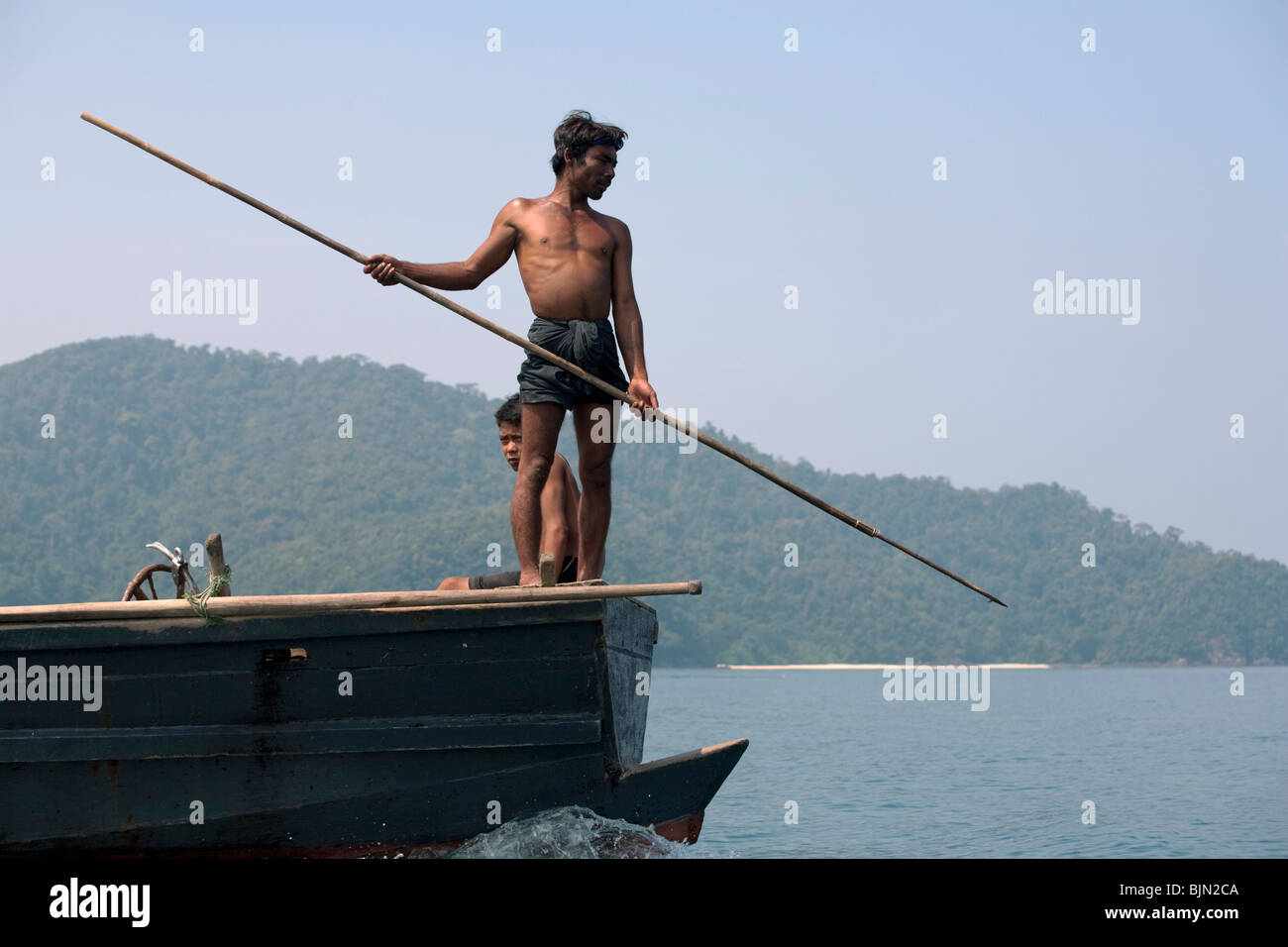 Myanmar sea-gypsies, the nomadic hunter-gatherers of South East Asia harpooning in the traditional way, from a boat prow. Stock Photo