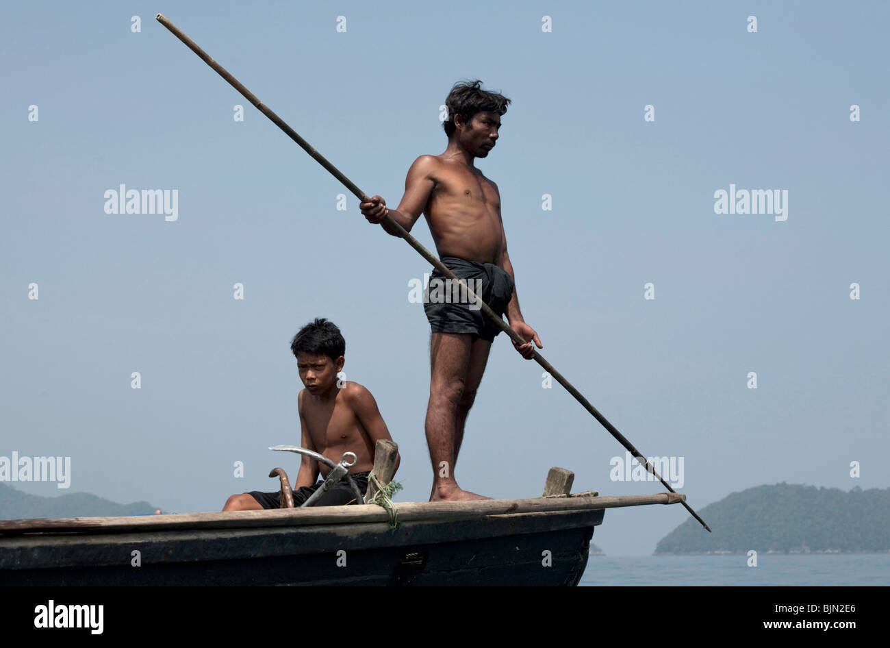 Myanmar sea-gypsies, the nomadic hunter-gatherers of South East Asia harpooning in the traditional way, from a boat prow. Stock Photo