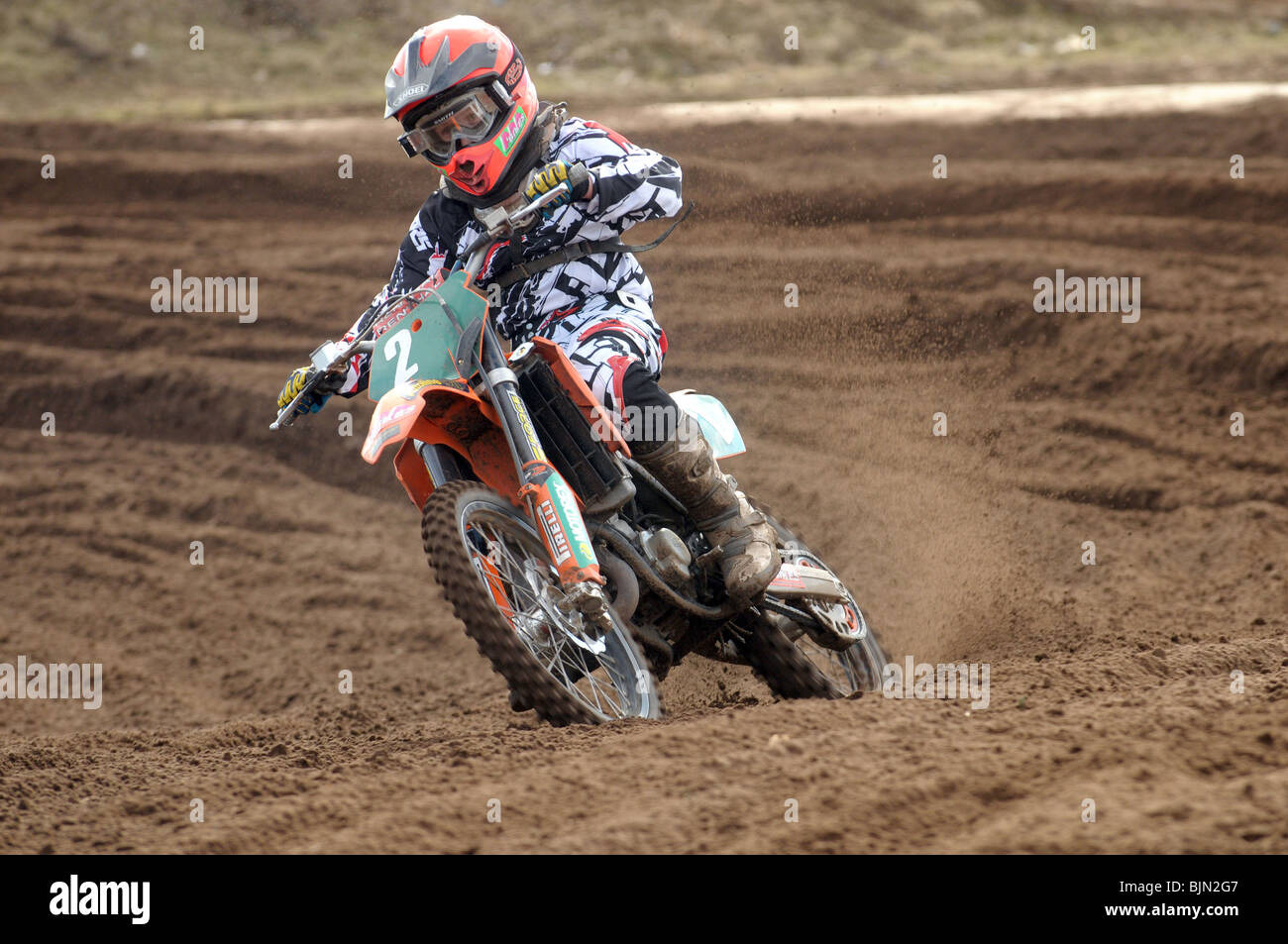 Young racer boy takes a bend on his motorcross bike Stock Photo - Alamy