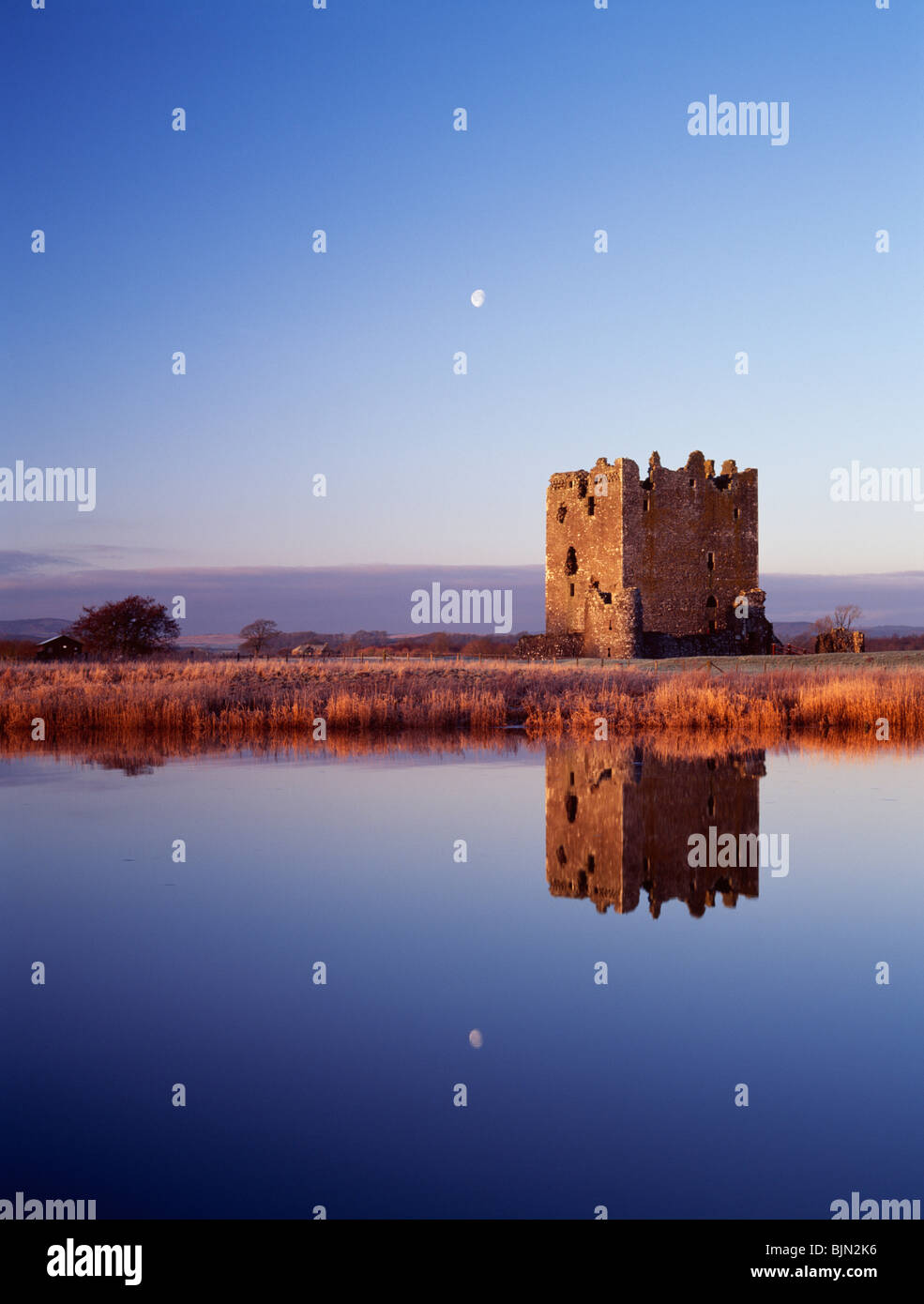 Early morning light on Threave Castle reflected in the River Dee with setting moon behind near Castle Douglas Scotland UK Stock Photo