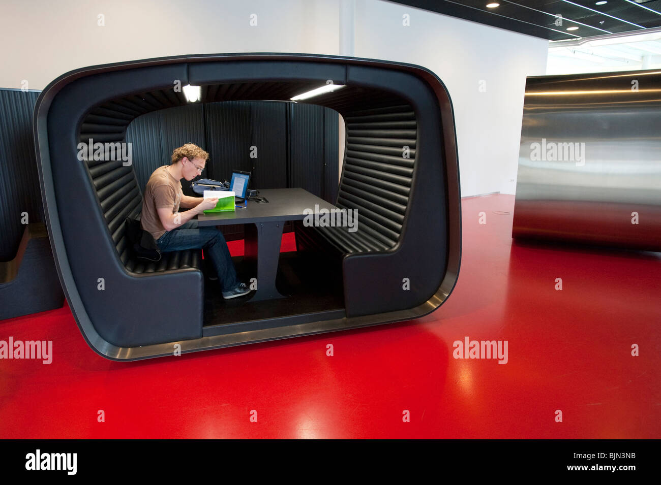 Student using modern study booth inside building on campus of Utrecht University in The Netherlands Stock Photo