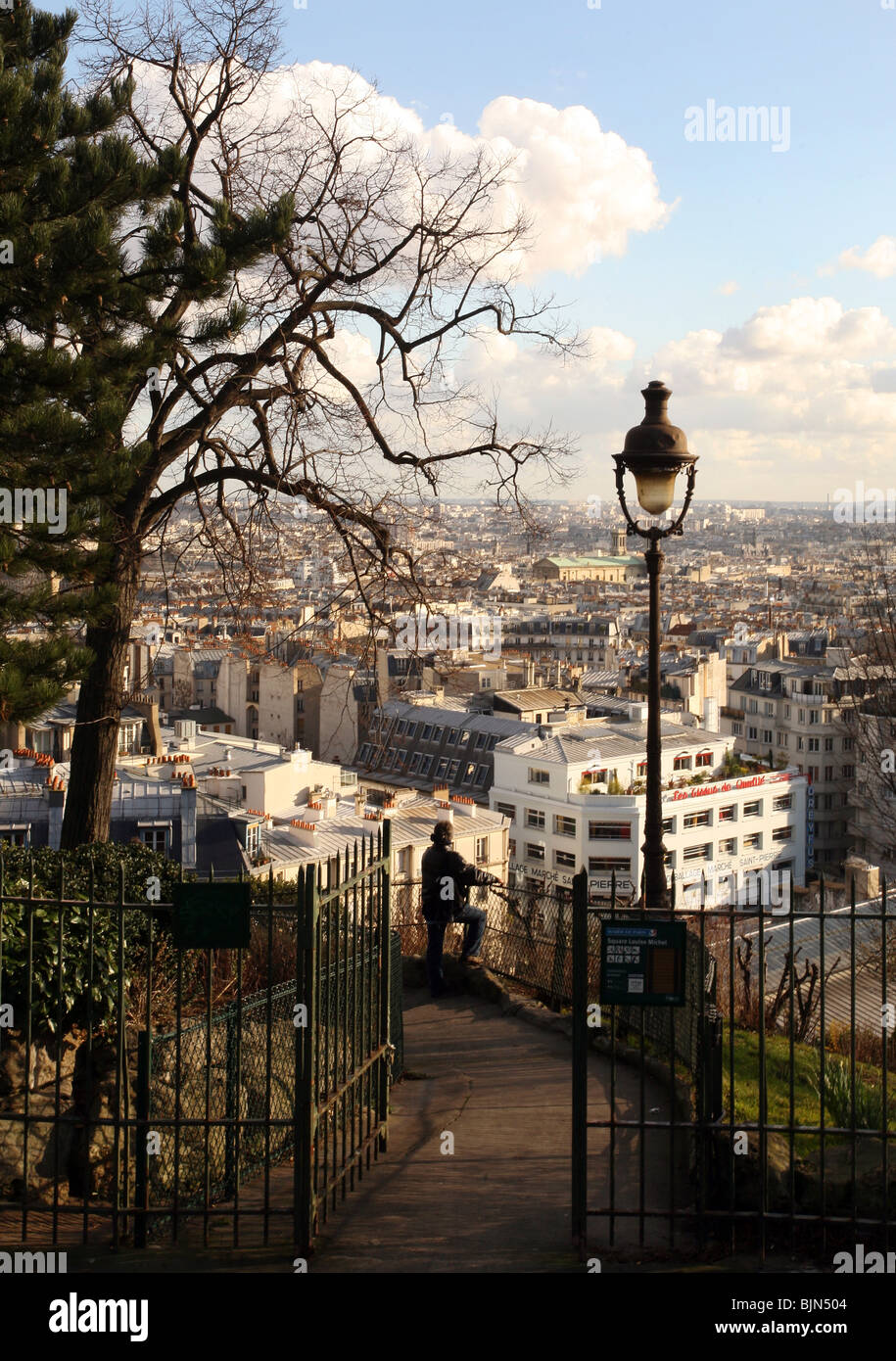 A visitor looks out onto Paris from the hill by the Sacre Coeur in Monmatre, Paris, France Stock Photo