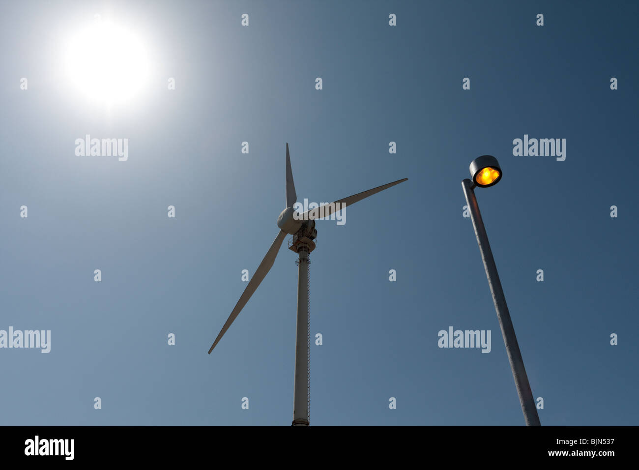 A wind turbine and streetlamp and the sun juxtaposed at the newly inaugurated bioclimatic village at the Instituto Tecnológico y Stock Photo