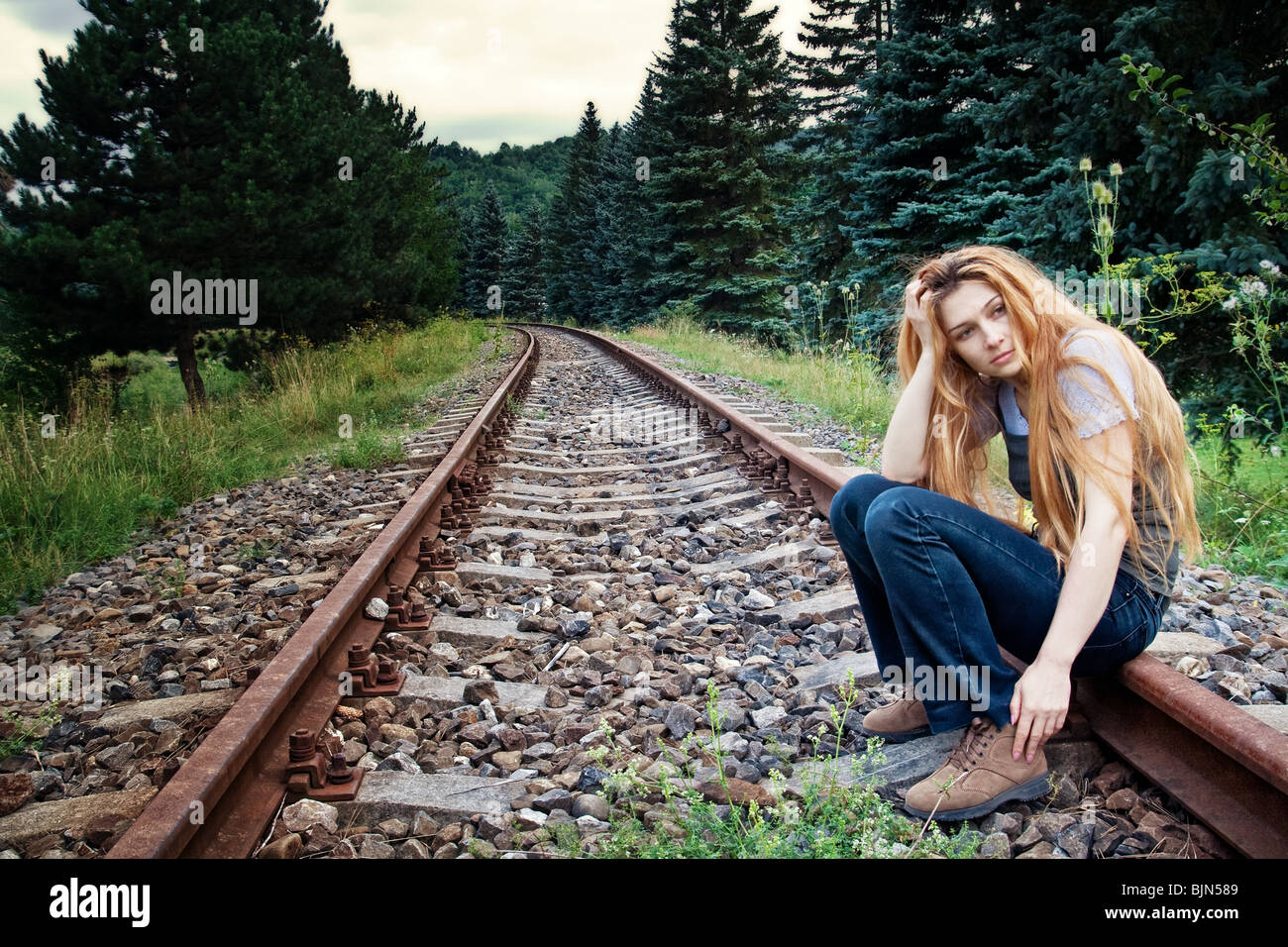 Sad suicidal lonely young woman on railway track Stock Photo