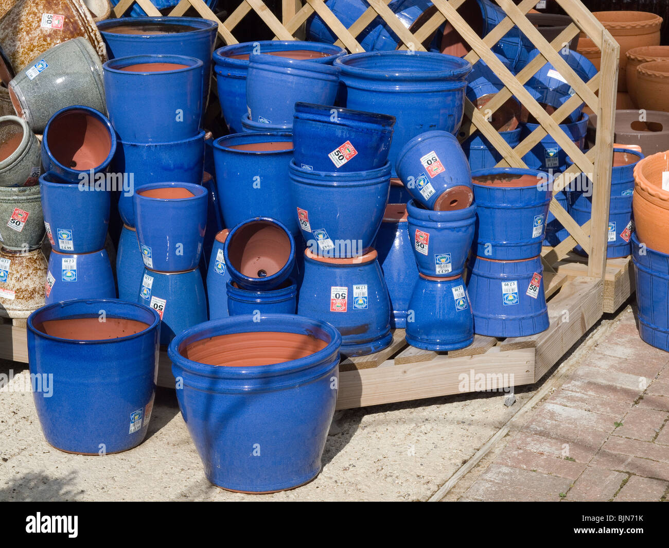 A pile of bright blue clay flower pots on special offer at a garden