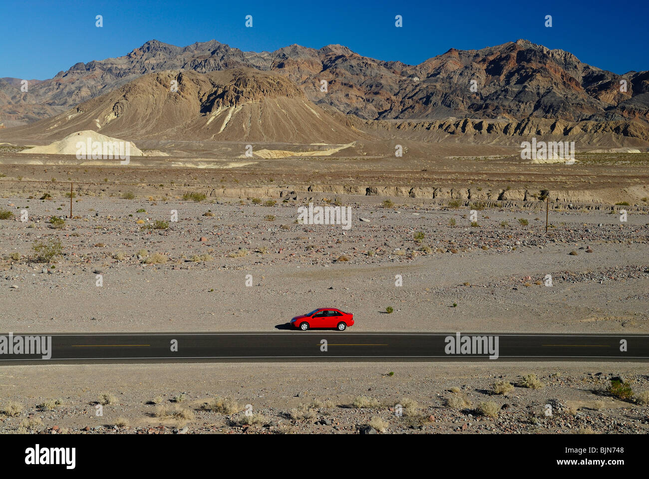 Red car parked along the SR190 road near Death Valley Junction. Stock Photo
