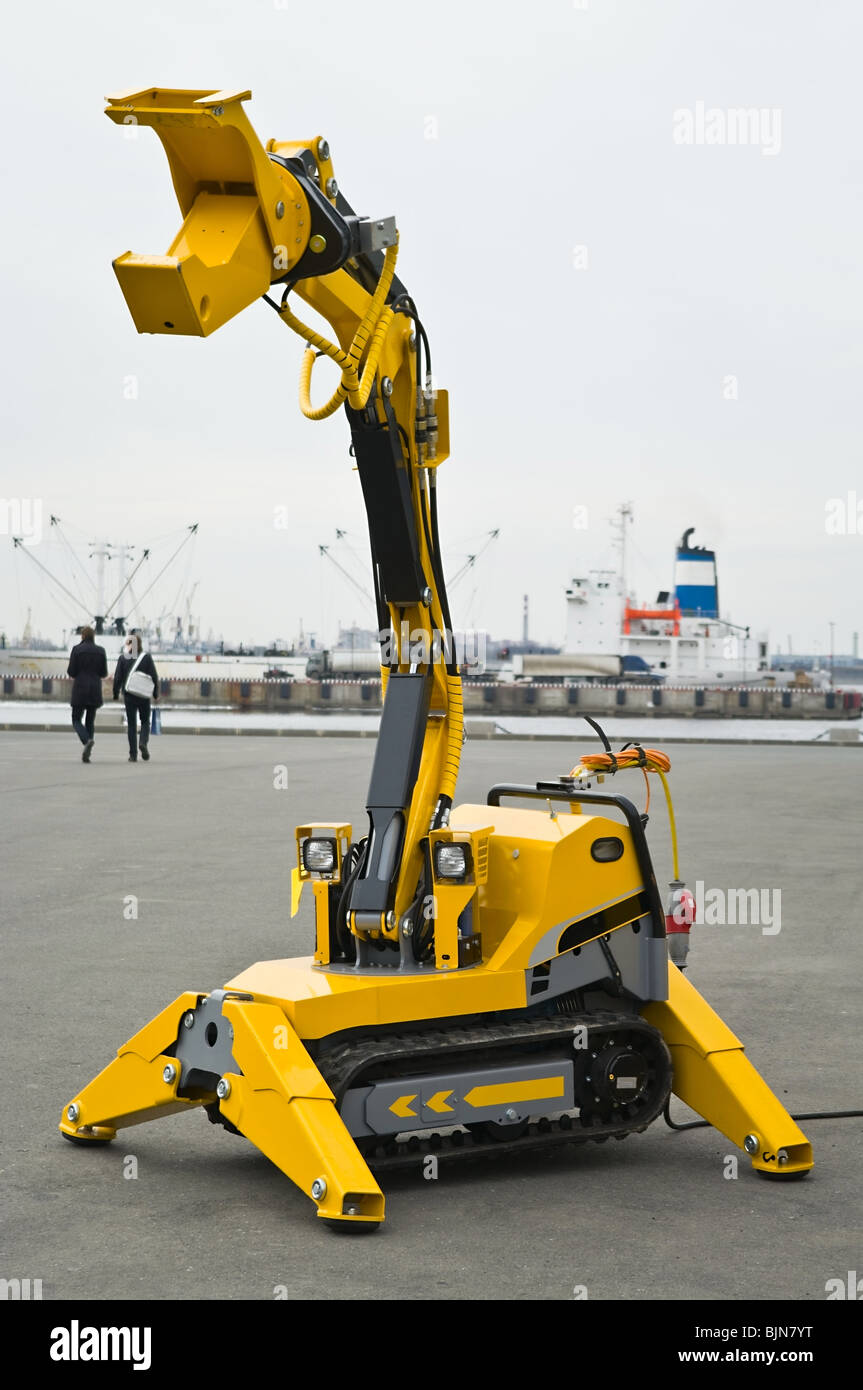 Yellow mechanical robotized mechanism with caterpillar. Gripping arm is opened. Stock Photo