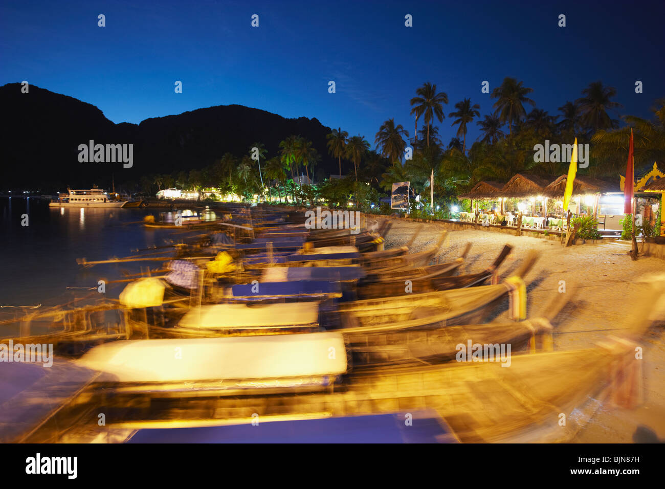Long tail boats on Ao Ton Sai Beach at dusk, Ko Phi Phi Don, Krabi Province, Thailand Stock Photo
