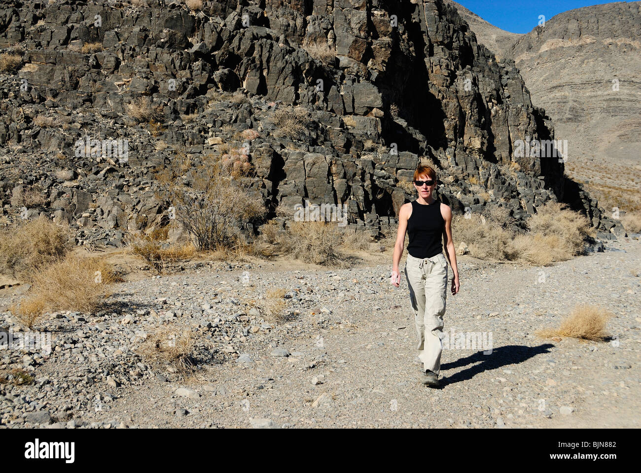 Woman walking on an arid pathway of Death Valley, California state Stock Photo