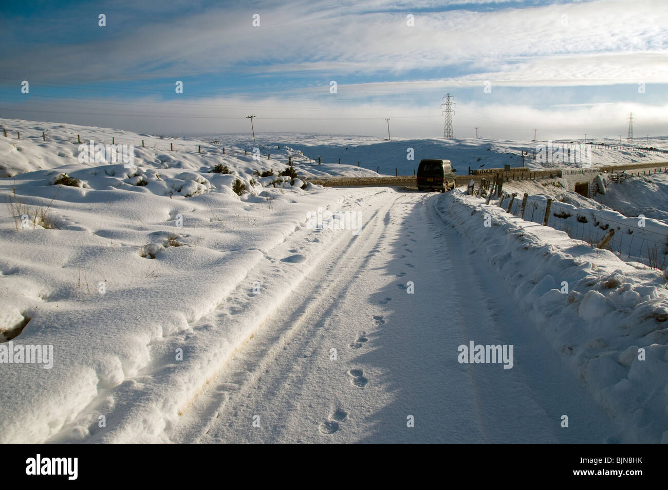 A car in a snow covered lay by on the A9 road in Caithness, Scotland, UK Stock Photo