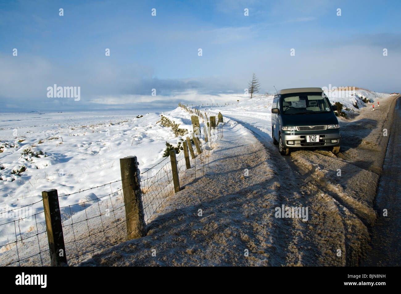 A car in a snow covered lay by on the A9 road in Caithness, Scotland, UK Stock Photo