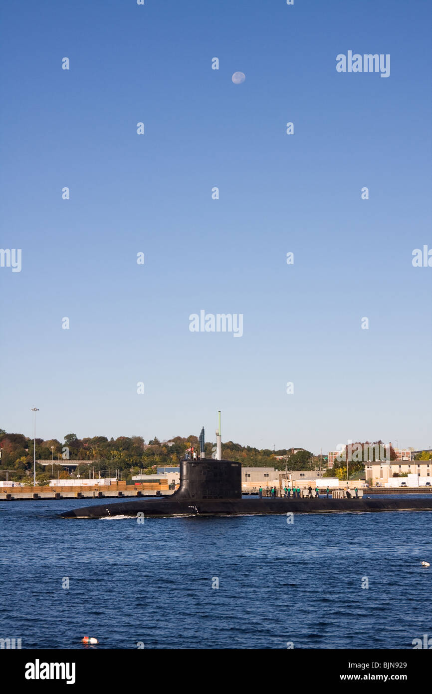 A US Navy Virginia class fast attack submarine heads south in the Thames River under a gibbous moon, New London, CT Stock Photo