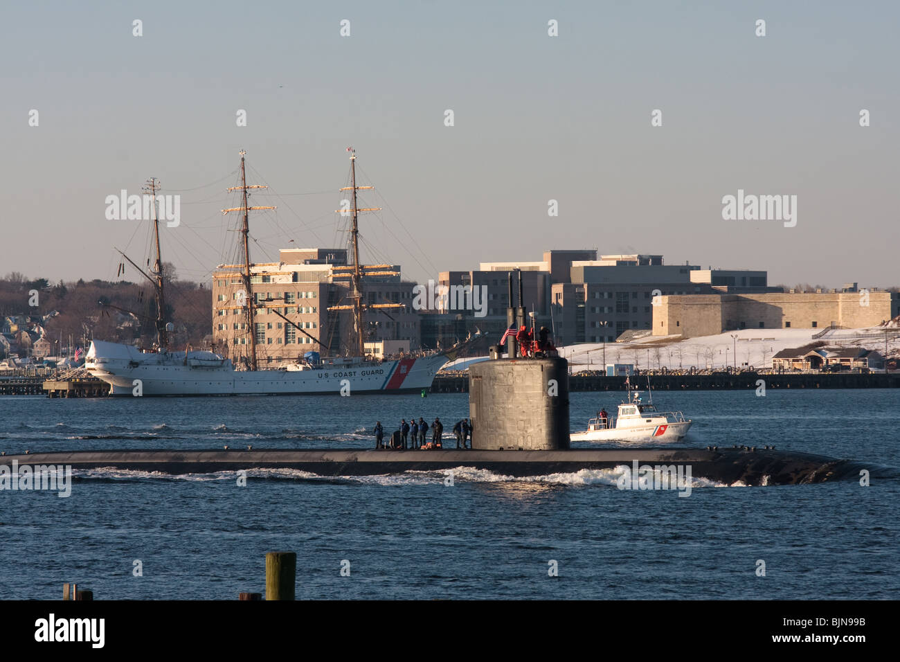 A US Navy Los Angeles class fast attack submarine heads north in the Thames River with the USCG Eagle in the background Stock Photo