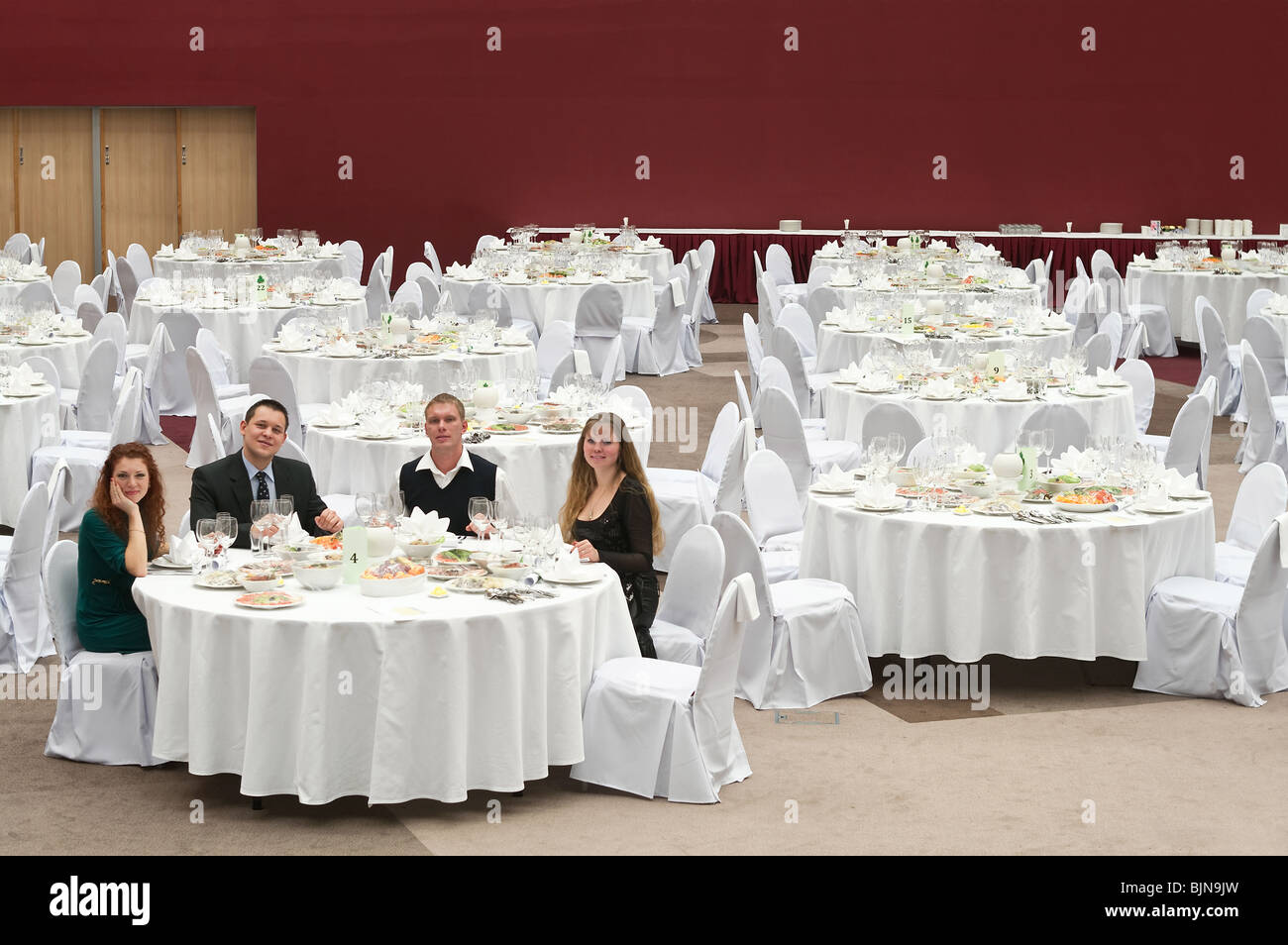 Group of young people sitting at a table in an empty room of the