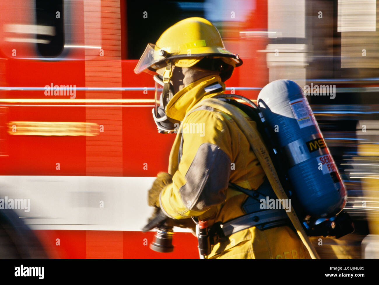 Fireman in Full Gear Running with Hose, USA Stock Photo