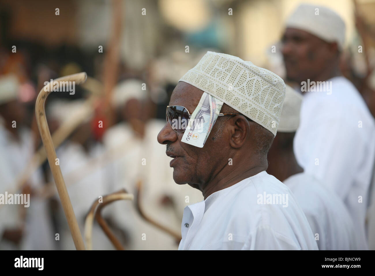 A man celebrating Maulidi outside Riyadha Mosque Lamu Kenya with money under his hat Stock Photo