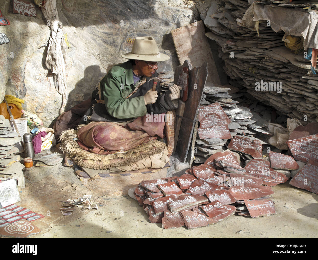 Man carves a Buddhist manta in a stone slab in Lhasa, Tibet Stock Photo
