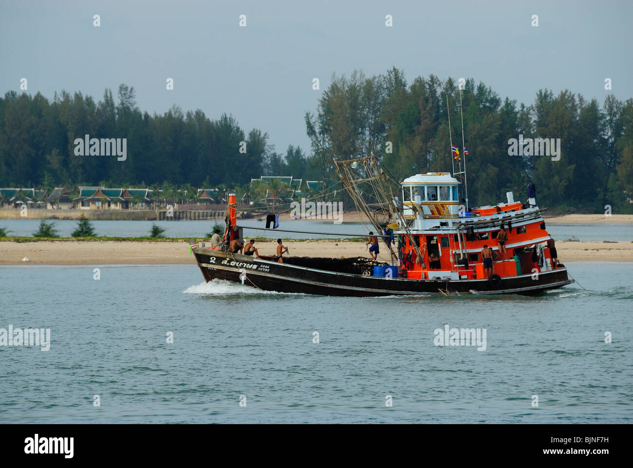 Wooden fishing boat leaving harbor of Ban Nam Khem, Thailand Stock Photo