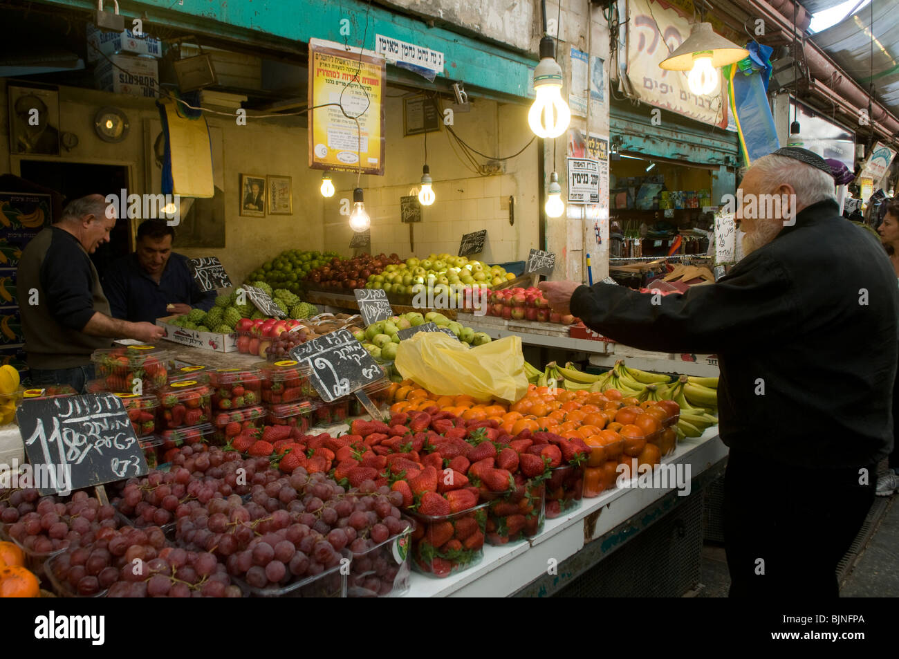 Man buying fruits in Mahane or Machane Yehuda market often referred to as 'The Shuk', an open-air, marketplace in West Jerusalem, Israel Stock Photo