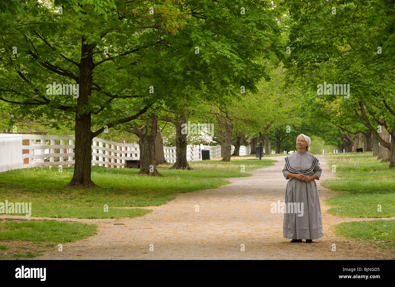 A story teller stands on path in front of the Centre Family Dwelling, Shaker Village, Pleasant Hill, Kentucky Stock Photo