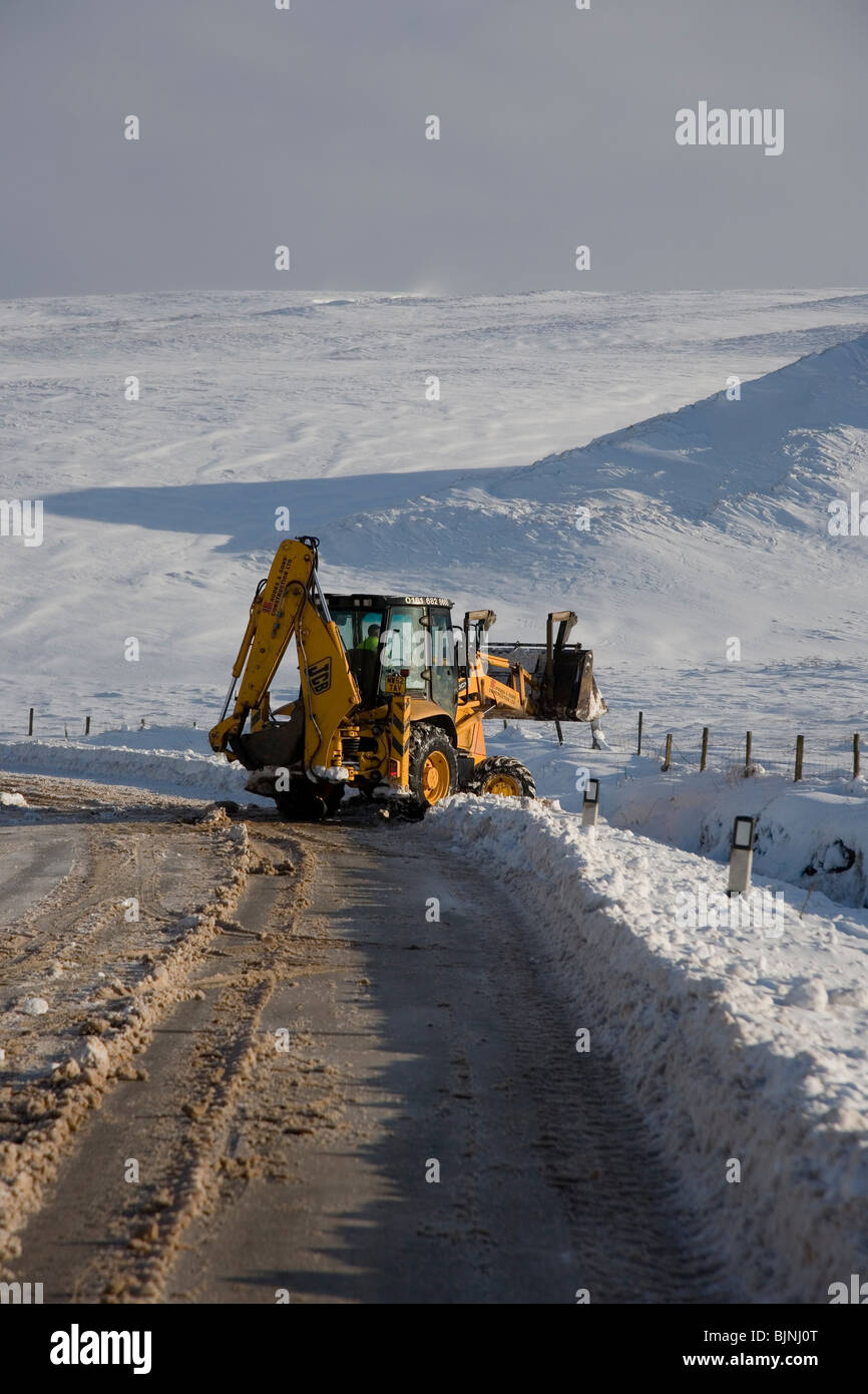 Snow Plough working to clear the A640 Rochdale Road at Saddleworth Moor, South Pennines, West Yorkshire, UK Winter 2009 09 Stock Photo