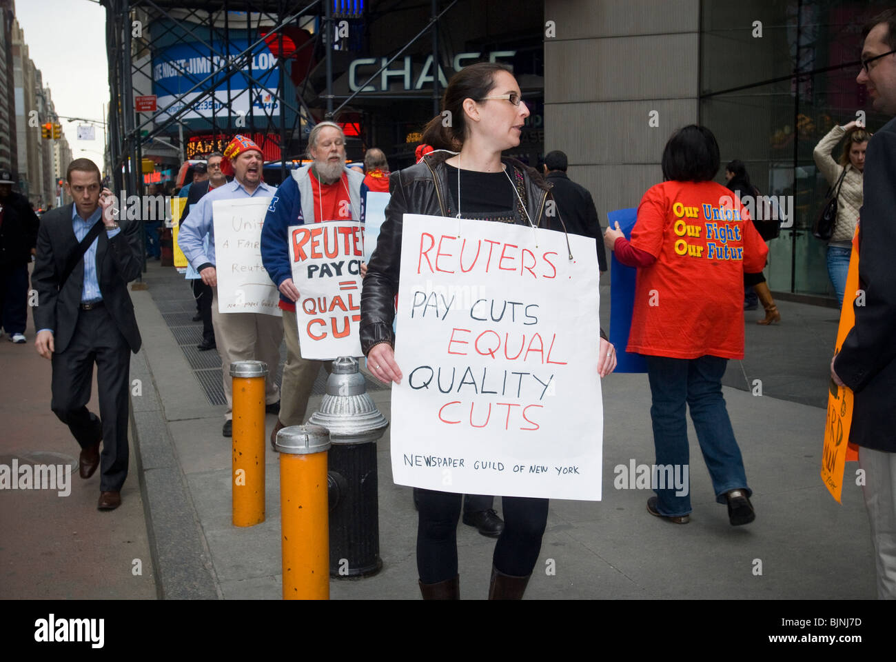 Members of the Newspaper guild of New York protest outside of the New York headquarters of Thomson Reuters in Times Square Stock Photo