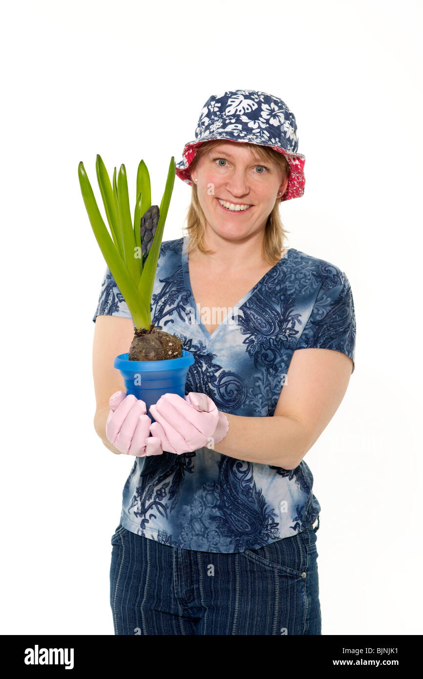 A smiling woman wearing a bucket hat shows off a hyacinth. Stock Photo