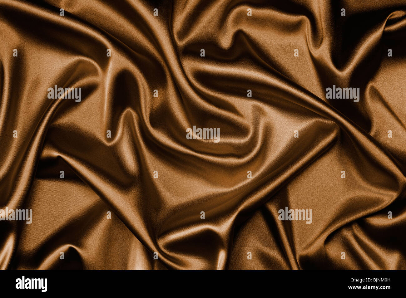 textile brown silk background draped in waves Stock Photo