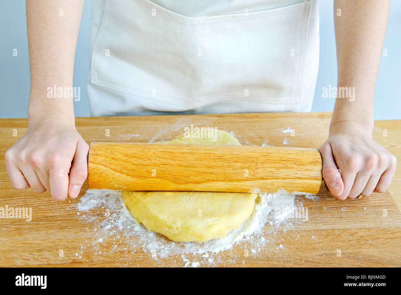 Spreading out cookie dough with wooden rolling pin Stock Photo Alamy