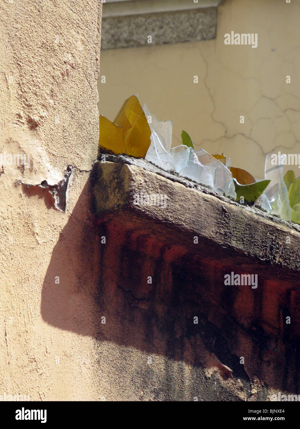 broken glass bottles used as a burglar intruder deterrent on high wall Stock Photo