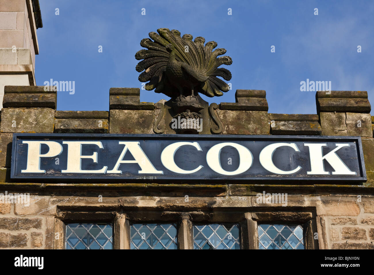 Sign and peacock sculpture on The Peacock Hotel at Rowsley near Bakewell in the Derbyshire Peak District. Stock Photo