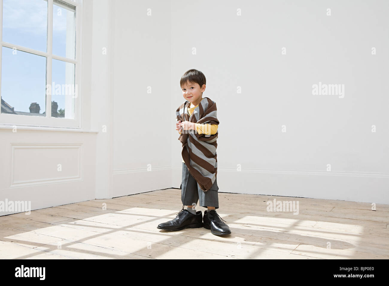 Boy dressing up in large clothes Stock Photo