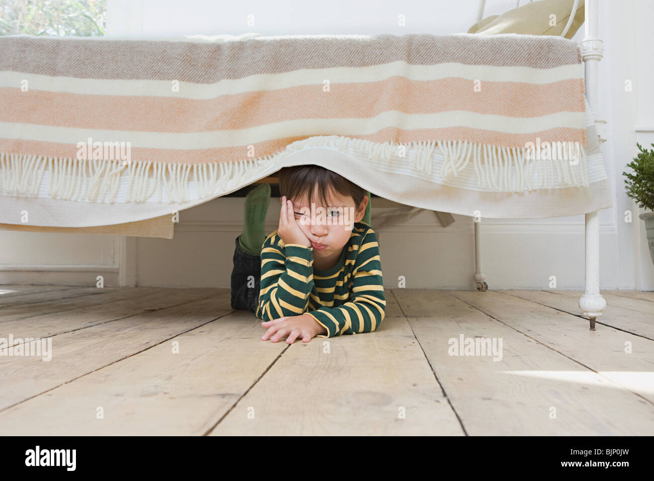 Boy hiding under a bed Stock Photo Alamy