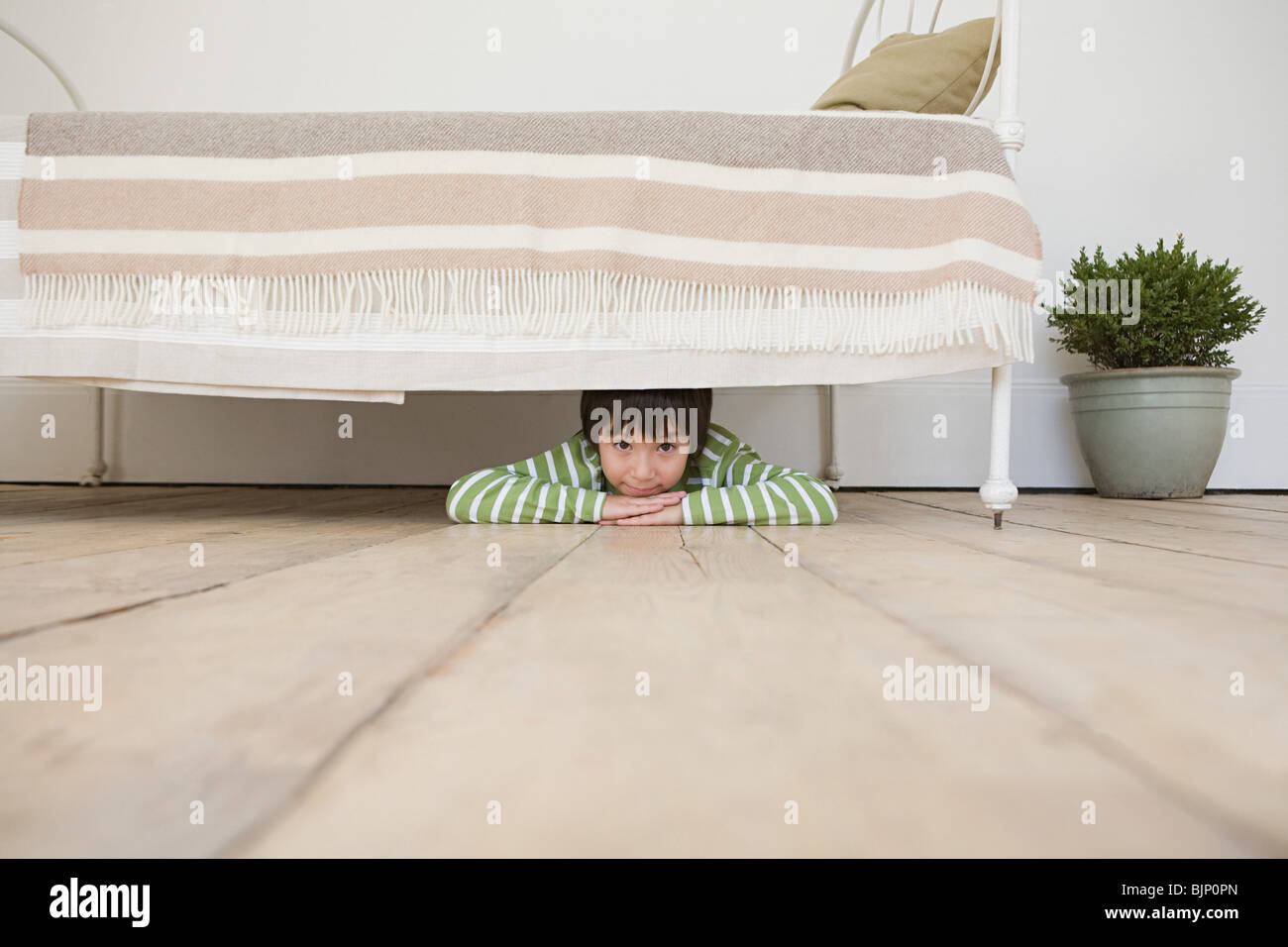 Boy hiding under a bed Stock Photo Alamy