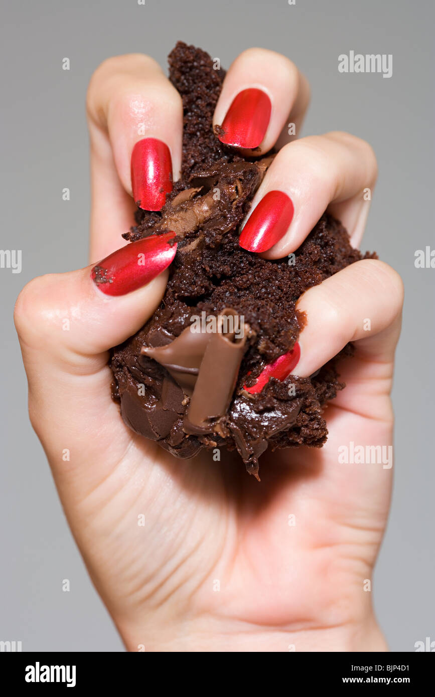 Woman crushing cake in her hand Stock Photo Alamy