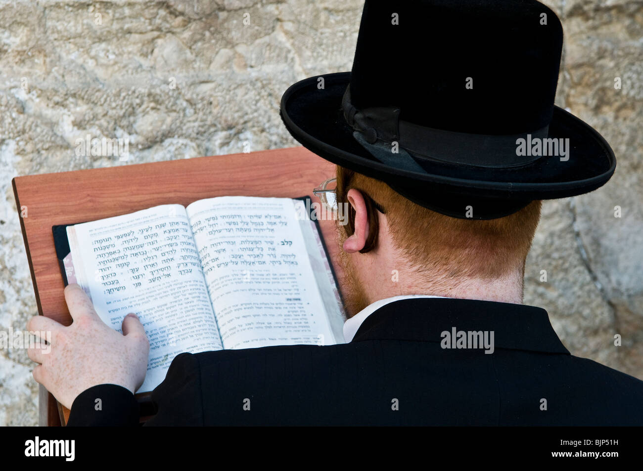 Studying the bible by the wailing wall Stock Photo Alamy