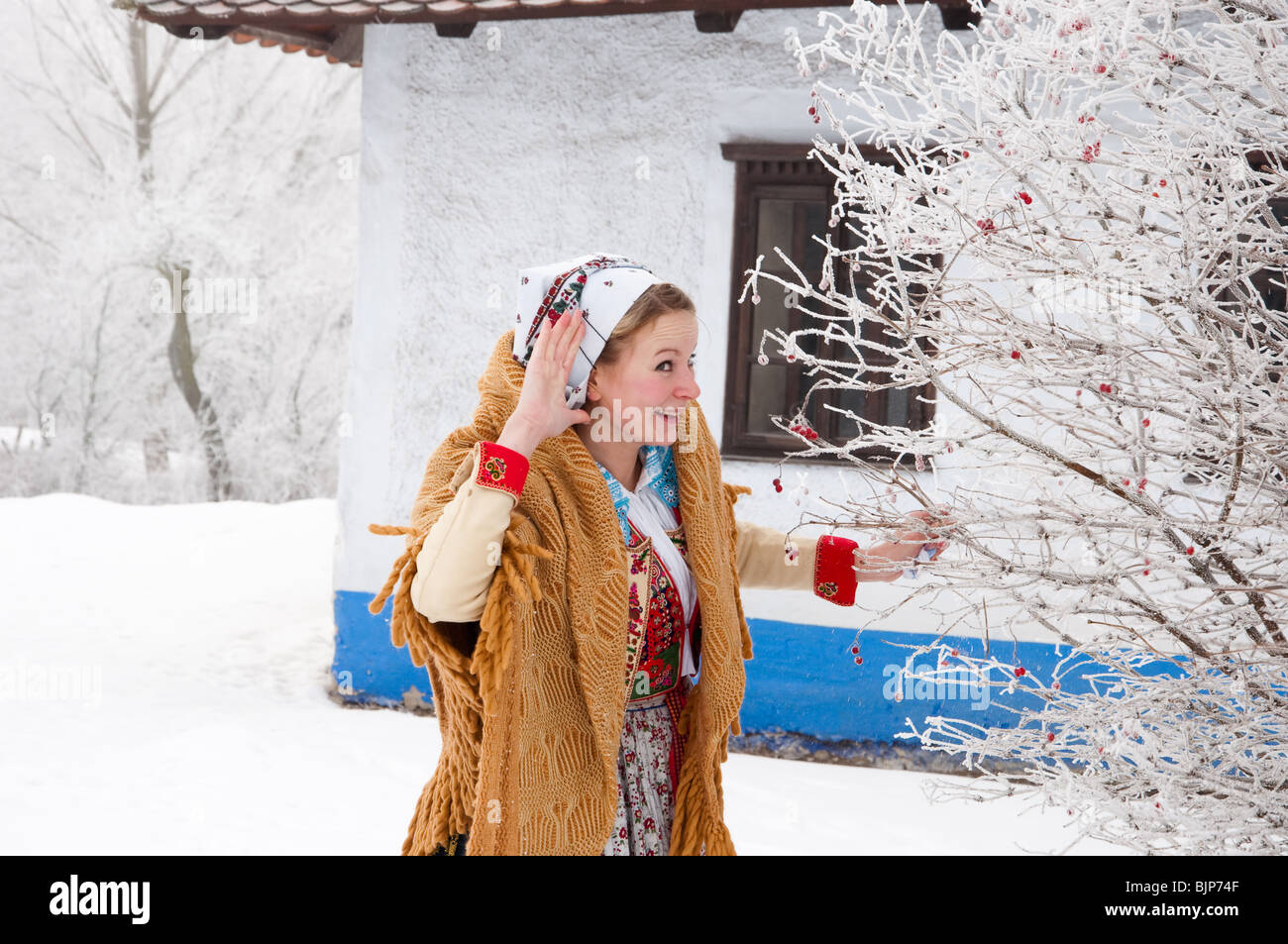 Girl in folk costume is listening in open air museum Stock Photo
