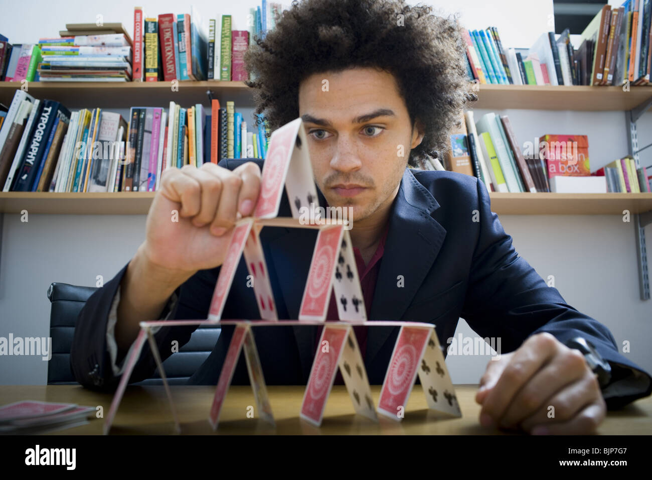 Man making a pyramid out of playing cards Stock Photo