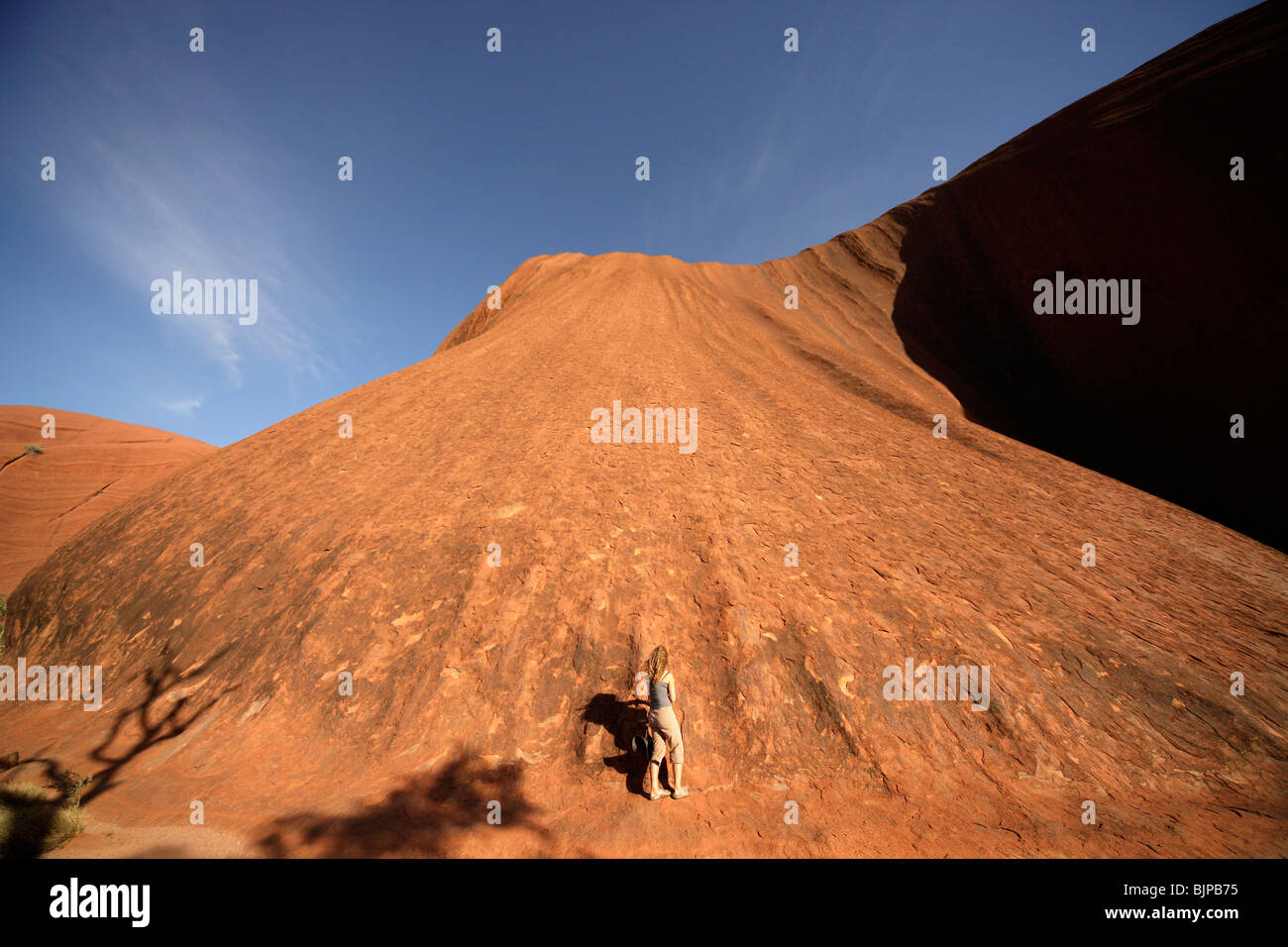female tourist at the world-renowned sandstone formation Uluru or Ayers Rock , Northern Territory, Australia Stock Photo