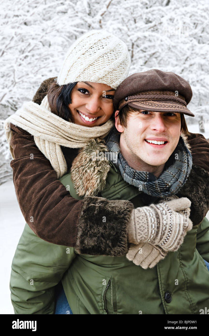 Portrait of couple having piggyback ride outdoors in winter Stock Photo ...