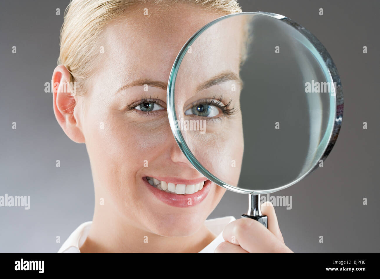 A woman holding a magnifying glass Stock Photo - Alamy