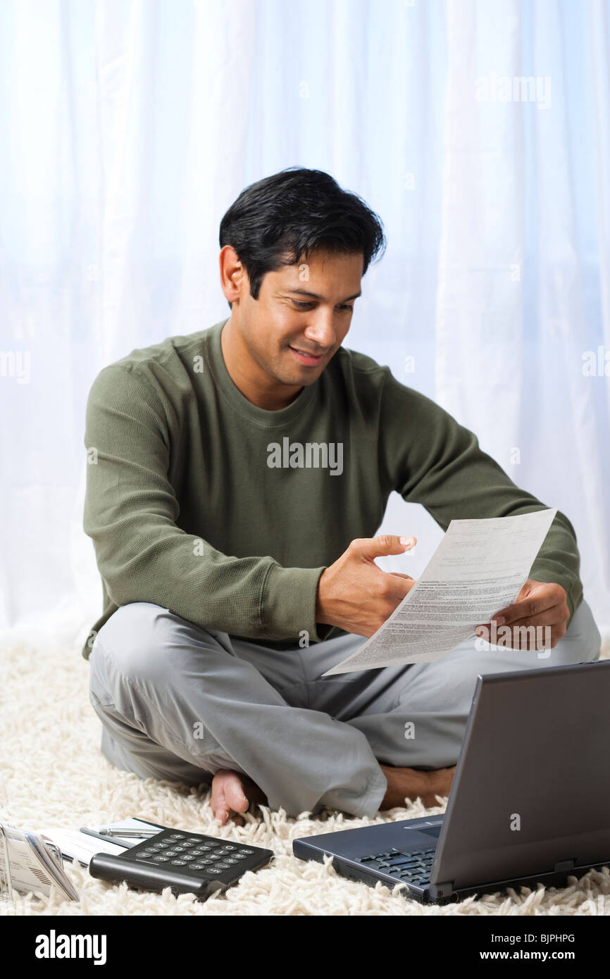 Man on carpet with laptop Stock Photo Alamy