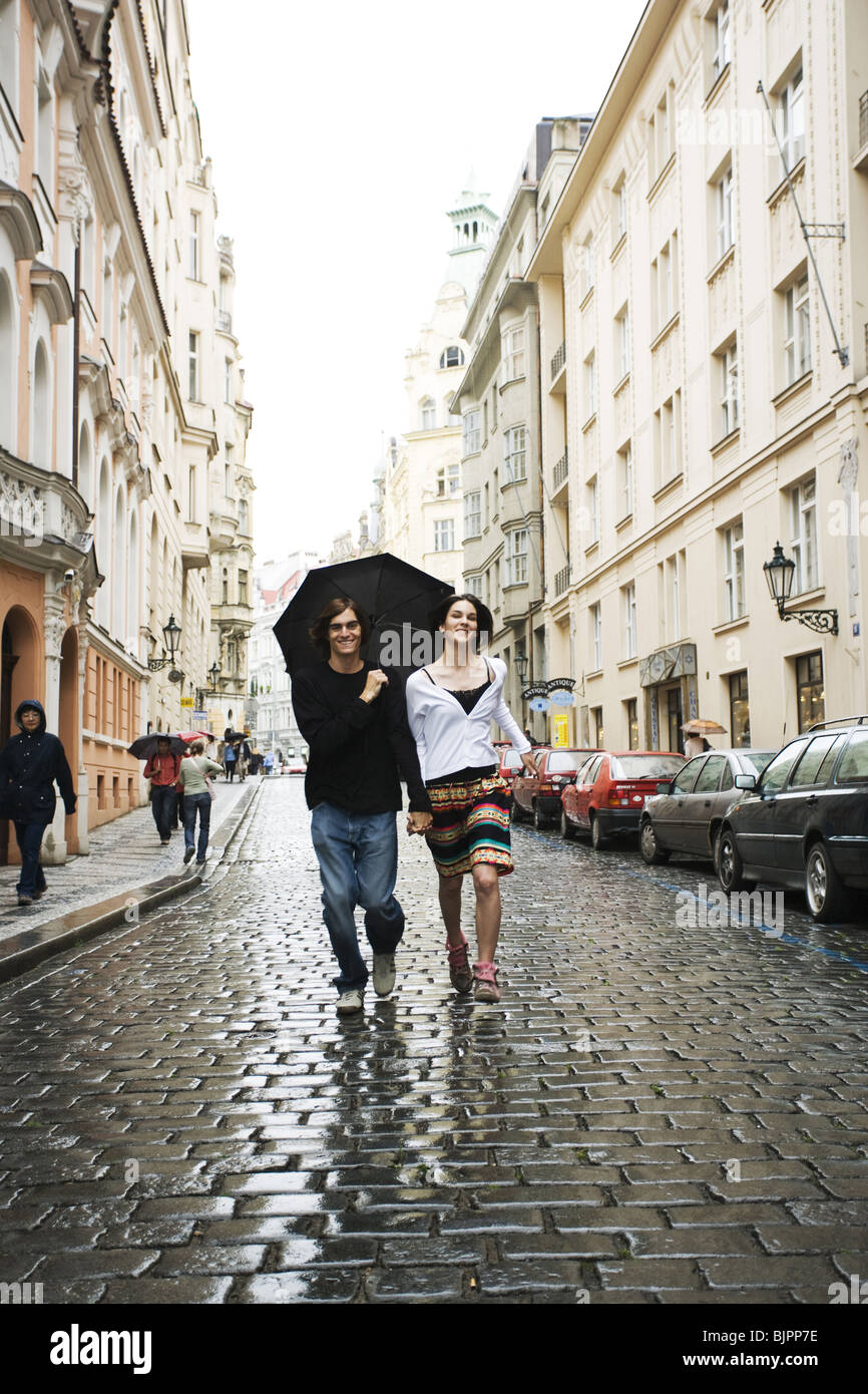 couple holding hands in rain