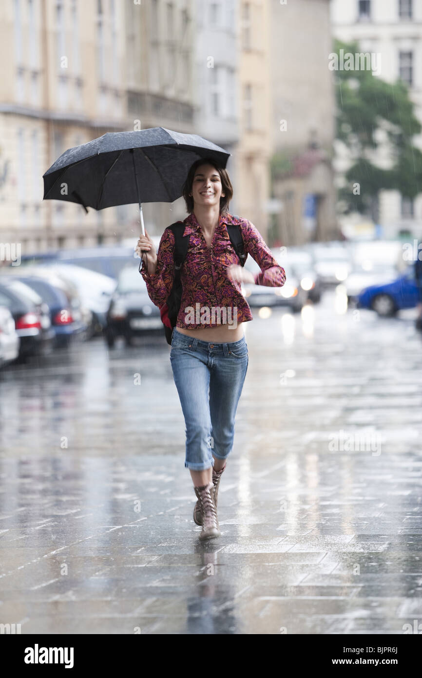 Woman walking down the street in the rain Stock Photo Alamy